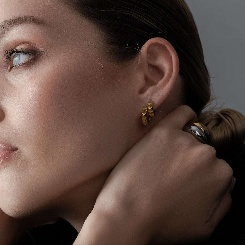 Mini sleeper hoop earrings with a pyramid spike detail in high quality 14k gold-plated stainless steel